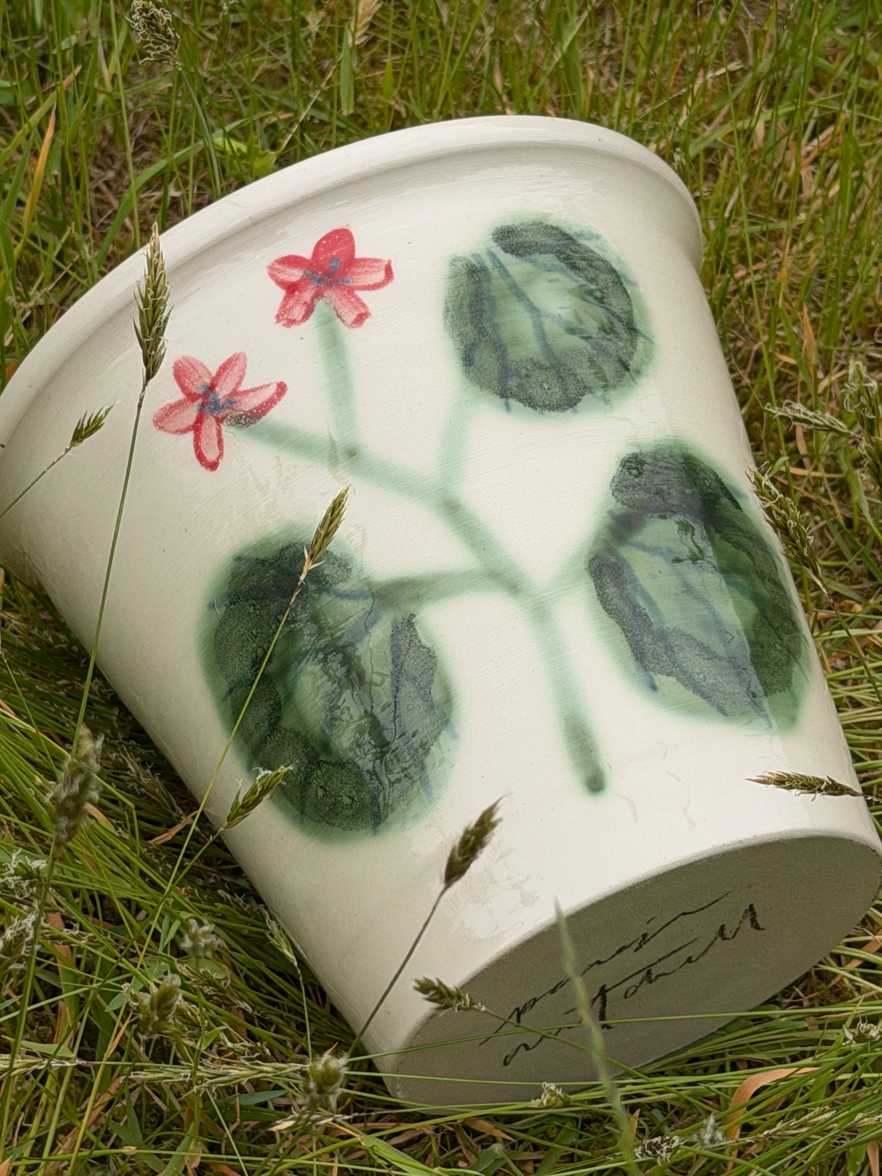 Ceramic vase with floral design on grass