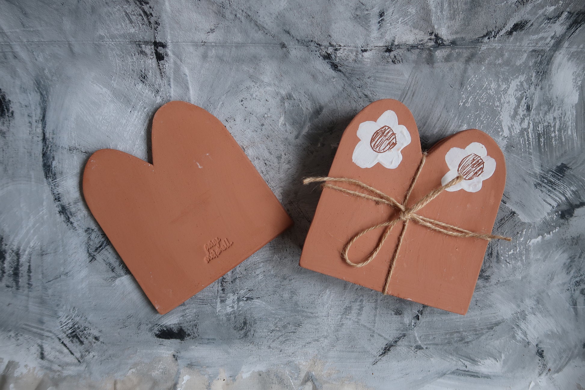 Terracotta boarder tiles for use in the garden.   Rolled out and cut by hand in terracotta clay, detailed with white slip, sgraffito daisies and stamped on the back.  Paige Mitchell. Handmade Ceramics.