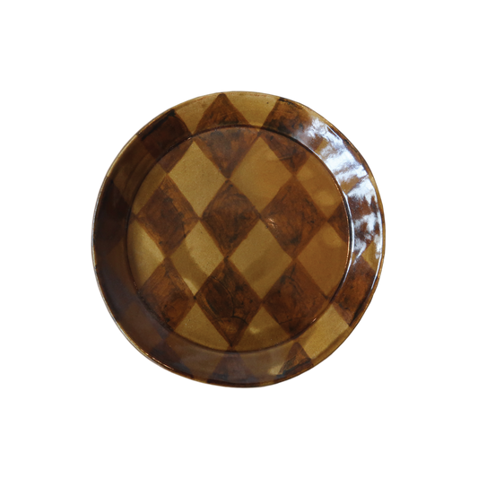 Stoneware plate, formed on a mould and painted by hand.  Fired once to 1000 degrees celsius, then signed, waxed, and dipped into a homemade glossy honey glaze. A harlequin pattern is painted by hand on top of the glaze. Once dry the piece is ready for its final 1230 degree firing.  Approximately:   19cm diameter    Paige Mitchell, Handmade Ceramics.